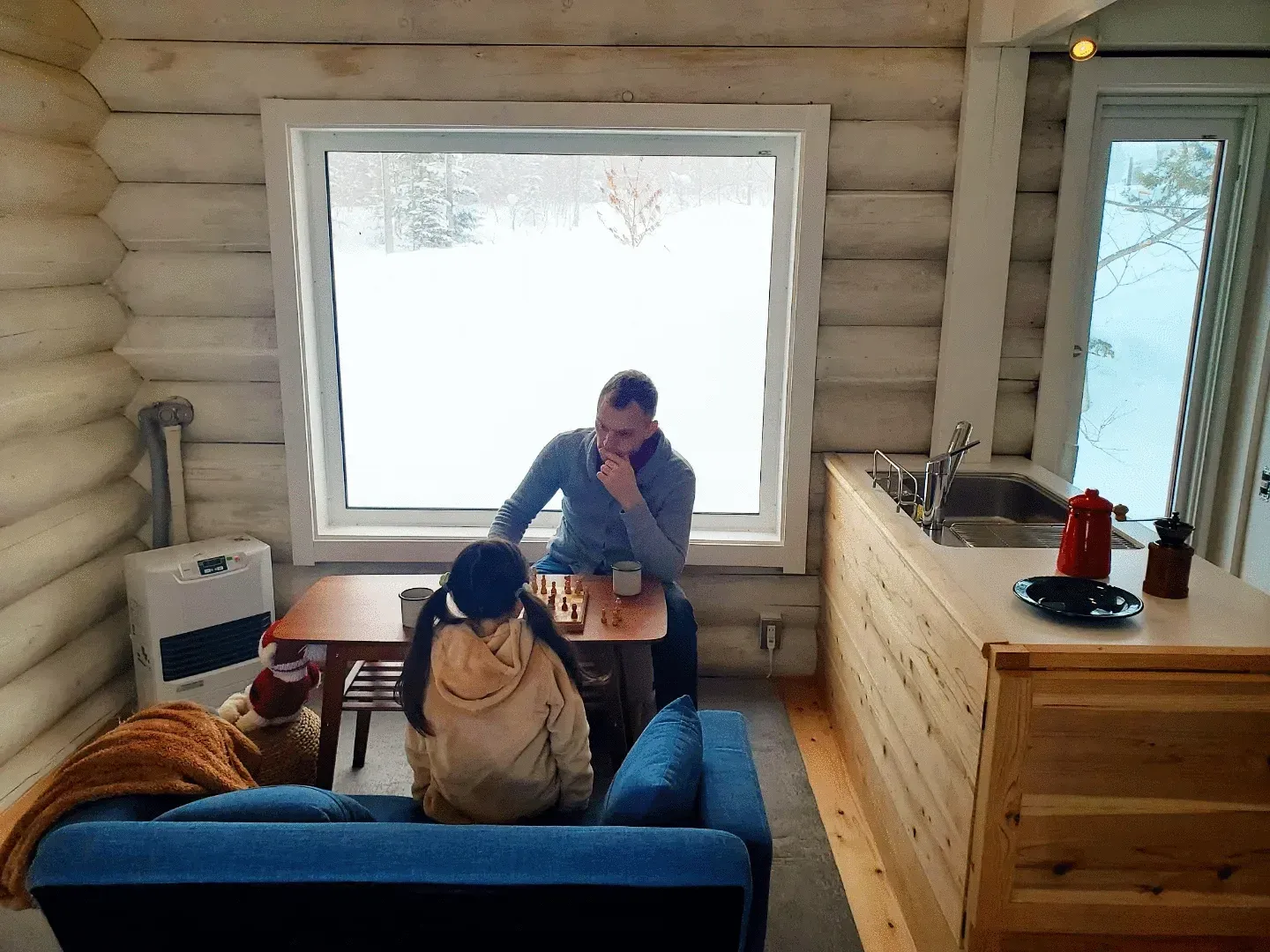 冬の室内でチェスを楽しむ親子の様子