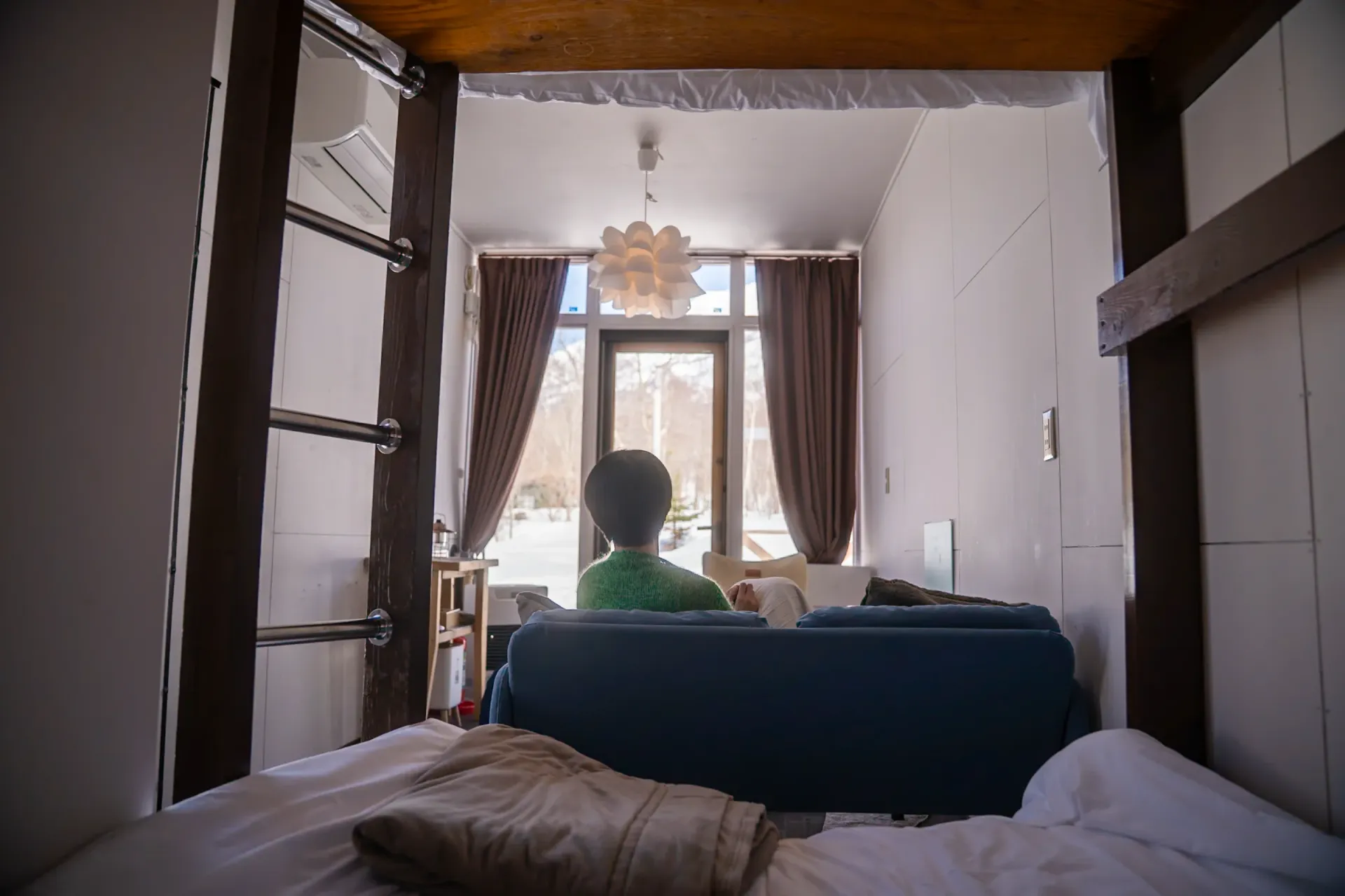 コンテナ内でリラックスする人と冬景色