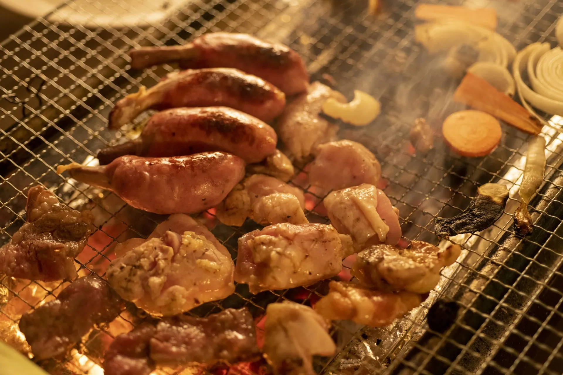 キャンプでバーベキューを楽しむ、焼けた肉と野菜