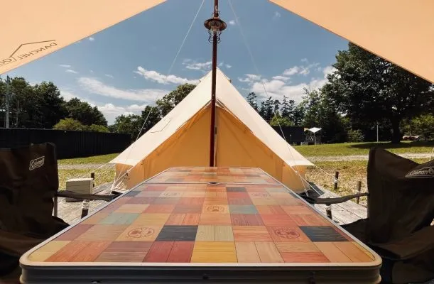 キャンプサイトのベルテントとカラフルなテーブル