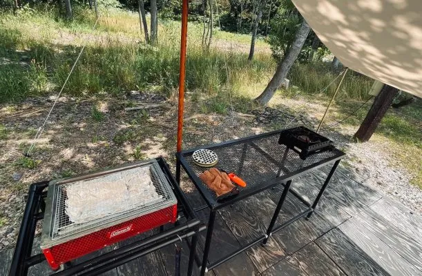 キャンプ場のバーベキュー設備と自然風景